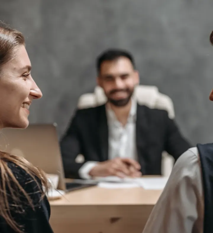 A relaxed meeting between advisors and a client across an office table.